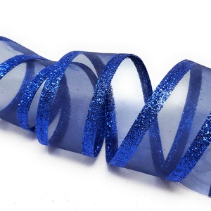 May include: Blue sheer ribbon with glitter trim. The ribbon is curled and twisted.
