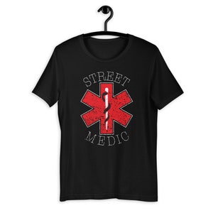 May include: Black t-shirt with a red star of life symbol and the text "STREET MEDIC" in white.