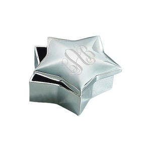 May include: A silver star-shaped trinket box with a hinged lid. The lid is engraved with a monogram.