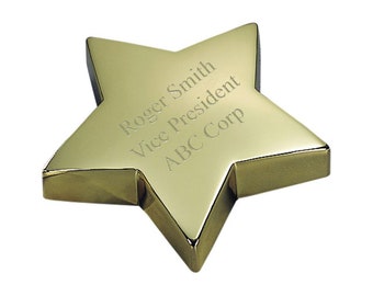 May include: A gold star-shaped award with the text "Roger Smith Vice President ABC Corp" engraved on the surface.