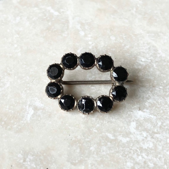 Black stone brooch deals