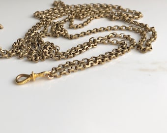 May include: A gold chain necklace with a small, decorative clasp. The chain is made of small, linked circles.