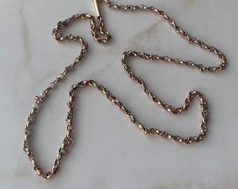 May include: A gold chain necklace with a twisted rope design. The chain is about 20 inches long and has a clasp.