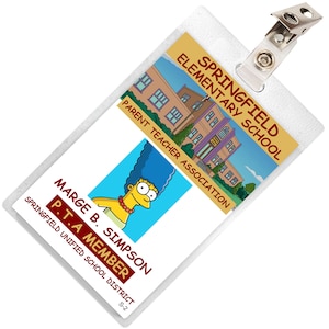May include: A white plastic badge with a cartoon image of Marge Simpson and the text "Springfield Elementary School Parent Teacher Association Marge B. Simpson P.T.A Member Springfield Unified School District S-2"