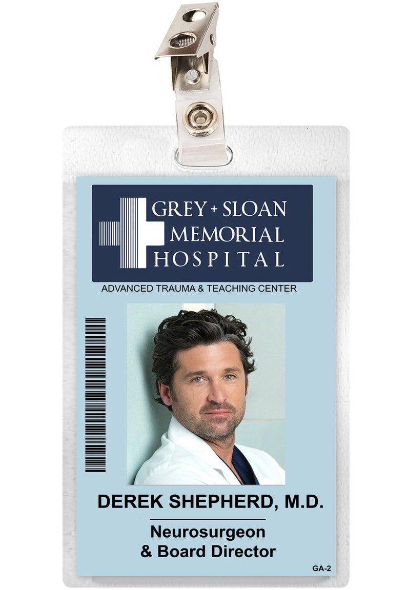 Puede incluir: Una tarjeta de identificaci&oacute;n de pl&aacute;stico blanco con fondo azul. La tarjeta tiene un logotipo del Grey Sloan Memorial Hospital, Centro de Trauma y Ense&ntilde;anza Avanzada. La tarjeta tiene una foto de un hombre con cabello oscuro y una bata blanca. El texto en la tarjeta dice "Derek Shepherd, M.D. Neurocirujano & Director de la Junta" y "GA-2".