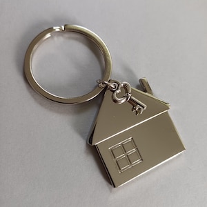 Könnte beinhalten: Eine weiße Keramik-Tasse mit schwarzem Henkel und dem Text "But First, Coffee" in fetter, schwarzer Schrift. Die Tasse steht vor einem neutralen Hintergrund, der ihr schlichtes Design hervorhebt.