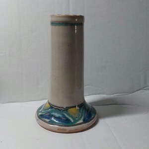 May include: A ceramic vase with a white body and a blue, green and yellow design around the base.