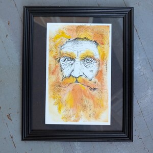 May include: Watercolor portrait of a man with a long orange beard and hair, framed in a black rectangular frame. The artwork features detailed linework and a warm color palette, creating a rustic aesthetic.