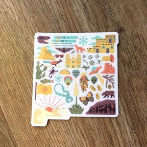 Op de afbeelding: Een witte sticker met een kleurrijke omtrek van de staat New Mexico. De sticker is gevuld met verschillende pictogrammen die de staat vertegenwoordigen, waaronder een kerk, een luchtballon, een chilipeper, een schorpioen, een beer, een vlinder en een zonsondergang. De tekst "66fourdesign.co" staat onderaan de sticker.