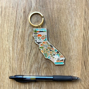 Peut inclure: Un porte-cl&eacute;s en m&eacute;tal dor&eacute; en forme de l'&eacute;tat de Californie. Le porte-cl&eacute;s est d&eacute;cor&eacute; d'illustrations color&eacute;es de divers monuments, activit&eacute;s et symboles californiens, notamment un ours, une plage, un palmier, une planche de surf et un coucher de soleil. Le porte-cl&eacute;s est dot&eacute; d'un anneau dor&eacute; fix&eacute; en haut.