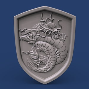 May include: A silver shield with a detailed 3D carving of a dragon. The dragon is curled up with its head facing forward and its claws visible.