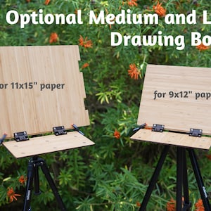 May include: Two wooden drawing boards on tripods, one for 11x15" paper and the other for 9x12" paper.  The boards are made of light brown bamboo and have black hinges.  The tripods are black metal.