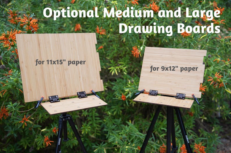 May include: Two wooden drawing boards on tripods, one for 11x15" paper and the other for 9x12" paper.  The boards are made of light brown bamboo and have black hinges.  The tripods are black metal.