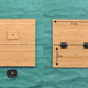 May include: A bamboo folding table with two hinges and a small square cutout in the top panel. The table is 11 inches wide, 6 inches deep, and 5 inches tall when folded. The table is made of natural bamboo and has a light brown color.