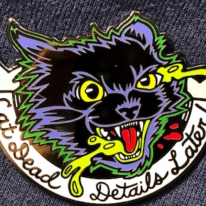 Puede incluir: Pin de esmalte de gato negro con ojos amarillos, lengua roja y vómito verde y amarillo. El pin tiene el texto "Cat Dead Details Later!" en una fuente blanca y curvada.