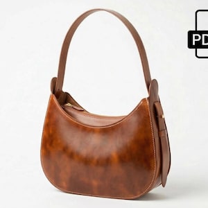 Könnte beinhalten: Eine braune Leder-Umhängetasche mit geschwungenem Design und einem einzelnen Henkel. Die Tasche hat einen Reißverschluss und ein kleines Riemendetail an der Seite. Das PDF-Symbol befindet sich in der oberen rechten Ecke.