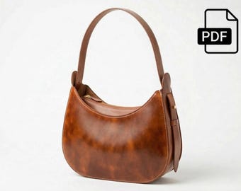 May include: A brown leather shoulder bag with a curved design and a single handle. The bag has a zipper closure and a small strap detail on the side. The PDF icon is in the upper right corner.