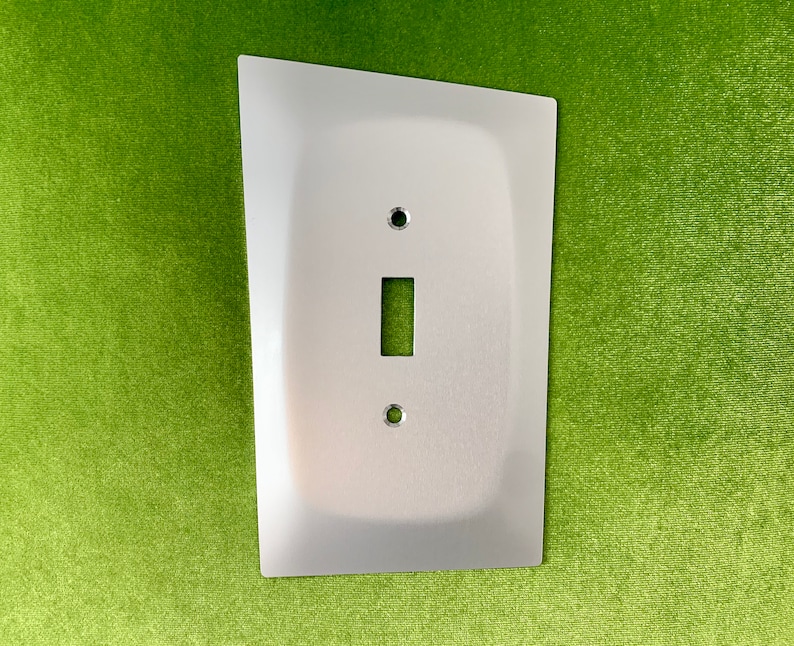 May include: A silver metal light switch cover plate with a single switch opening and two screw holes.
