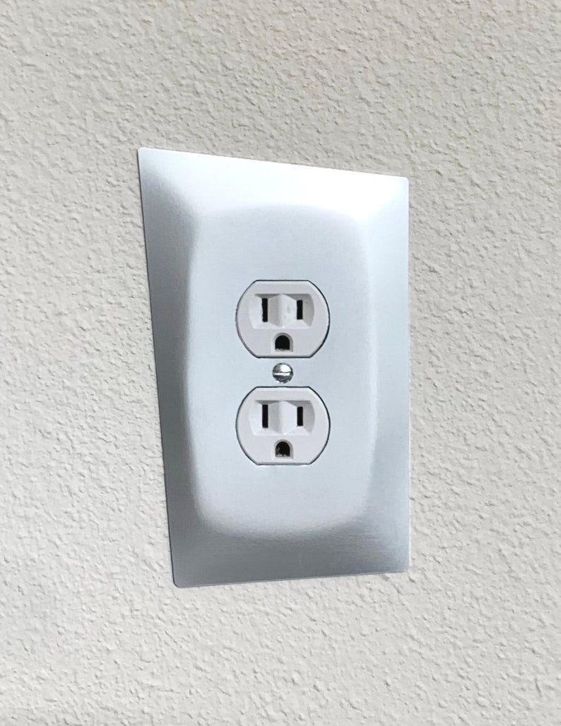 May include: A white electrical outlet with two standard outlets and a ground fault circuit interrupter (GFCI) button.