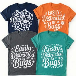 May include: Four t-shirts in navy blue, orange, charcoal gray, and teal. Each shirt features the white text "Easily Distracted by Bugs" in a whimsical font, with bug illustrations. The shirts are short-sleeved.