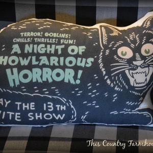May include: A black cat pillow with a white outline and green eyes. The pillow has the text "Terror! Goblins! Chills! Thrills! Fun! A Night of Howlarious Horror! Friday the 13th Midnite Show" printed on it.