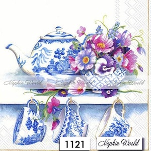 May include: A blue and white teapot with a floral design sits on a shelf with two blue and white teacups. The teapot and teacups are decorated with a floral pattern. The shelf is decorated with a floral design. The image includes the text "Napkin World" and the number "1121".