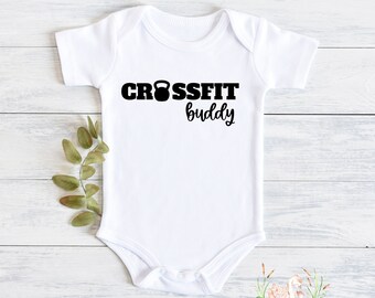 May include: White baby onesie with black text that reads "CROSSFIT buddy" with a black kettlebell icon.