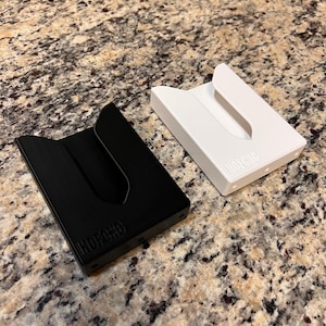 Puede incluir: Dos porta tarjetas minimalistas, uno negro y otro blanco, con la palabra "HUFFORD" en relieve en la parte inferior.