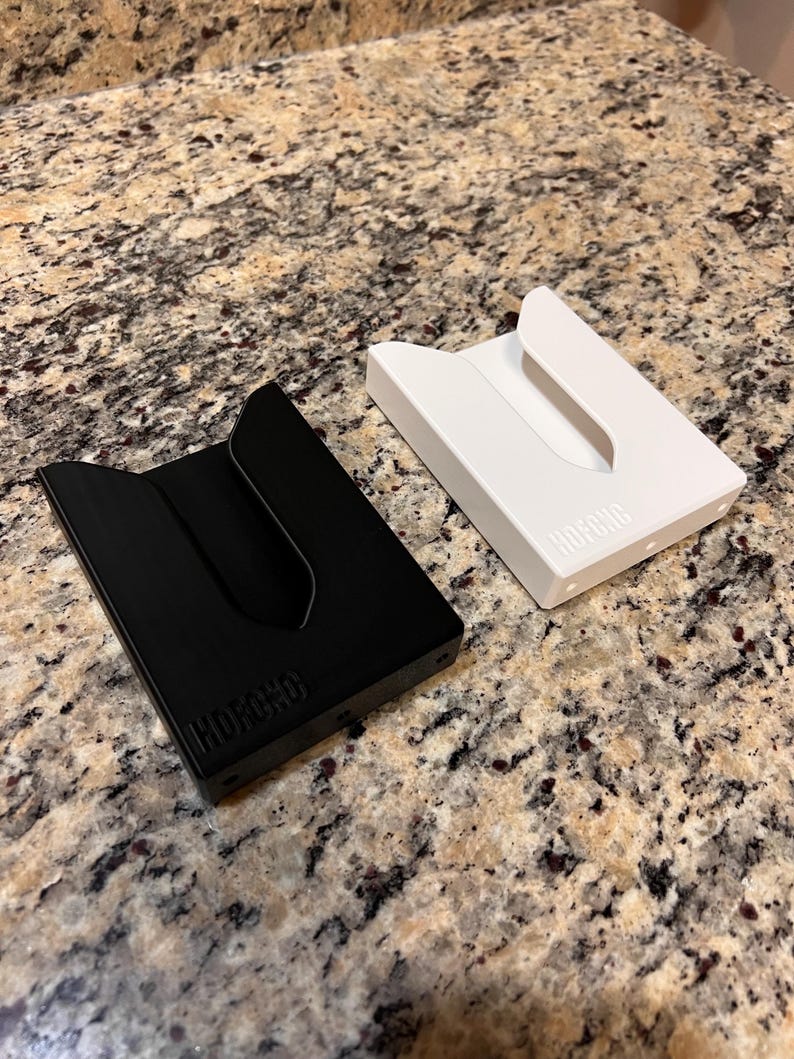 Puede incluir: Dos porta tarjetas minimalistas, uno negro y otro blanco, con la palabra "HUFFORD" en relieve en la parte inferior.