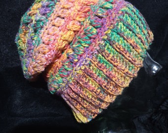 Unisex, wool mix beanie in rainbow tones, sized to fit medium to large adult.