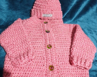 Hand crocheted, woollen, toddler cardigan in dusky pink tones with tweed flecks sized to fit 2 to 4 year old with matching hat