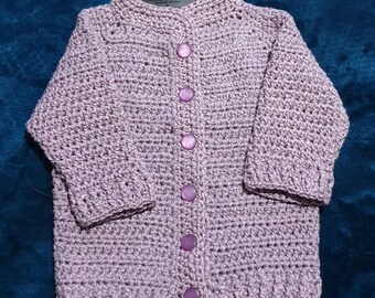 Gorgeously soft, mauve baby cardigan sized to fit a newborn to 3 months.