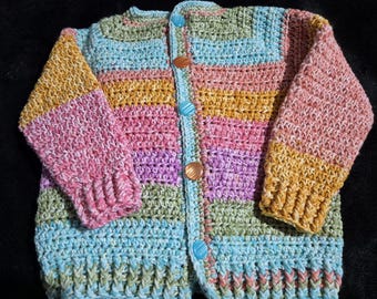 Hand crocheted, easy care acrylic baby or toddler cardigan in pastel rainbow tones sized to fit 12 to 24 months old.