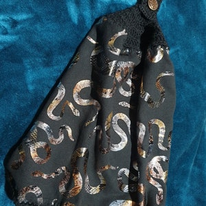 Novelty metallic snake design, luxury, 100% cotton towel with crochet top and bottom for use in kitchen or bathroom.