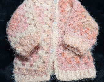 Gorgeously supersoft, variegated apricot baby cardigan sized to fit a newborn to 3 months.