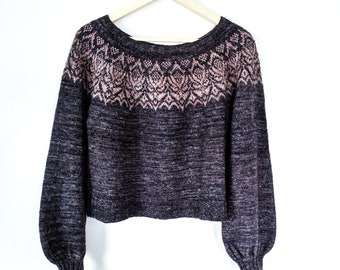 May include: A dark gray and pink knitted sweater with a geometric pattern around the neckline.