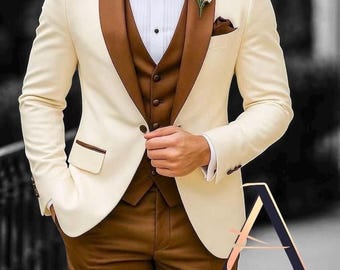 Könnte beinhalten: Ein cremefarbener Anzug mit braunen Revers, Weste und Hose. Der Anzug hat eine braune Fliege, ein weißes Hemd und eine kleine weiße Blume am Revers. Teil der Affashion Men's Women Collection.
