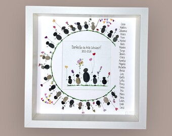 May include: A framed artwork with a white border. The artwork features a circular design with pebble figures holding balloons and flowers. Text reads "Danke für die tolle Schulzeit! 2023-2026" and a list of names.