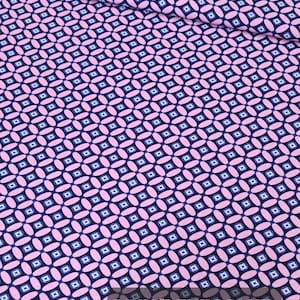 May include: Pink and denim blue fabric with a repeating pattern of small squares and ovals.