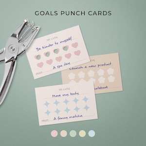 May include: Goal punch cards with a silver hole punch. The cards feature goals such as "Be kinder to myself" and "Move my body." Prizes include "A spa day" and "A fancy matcha." The text "GOALS PUNCH CARDS" is at the top. The cards are in cm.