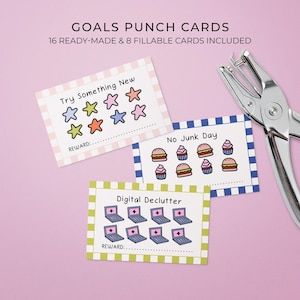 May include: Goal punch cards in pink, blue, and green, featuring illustrations of stars, cupcakes, burgers, and laptops. The cards are labelled "Try Something New", "No Junk Day", and "Digital Declutter". A silver hole punch is also visible.