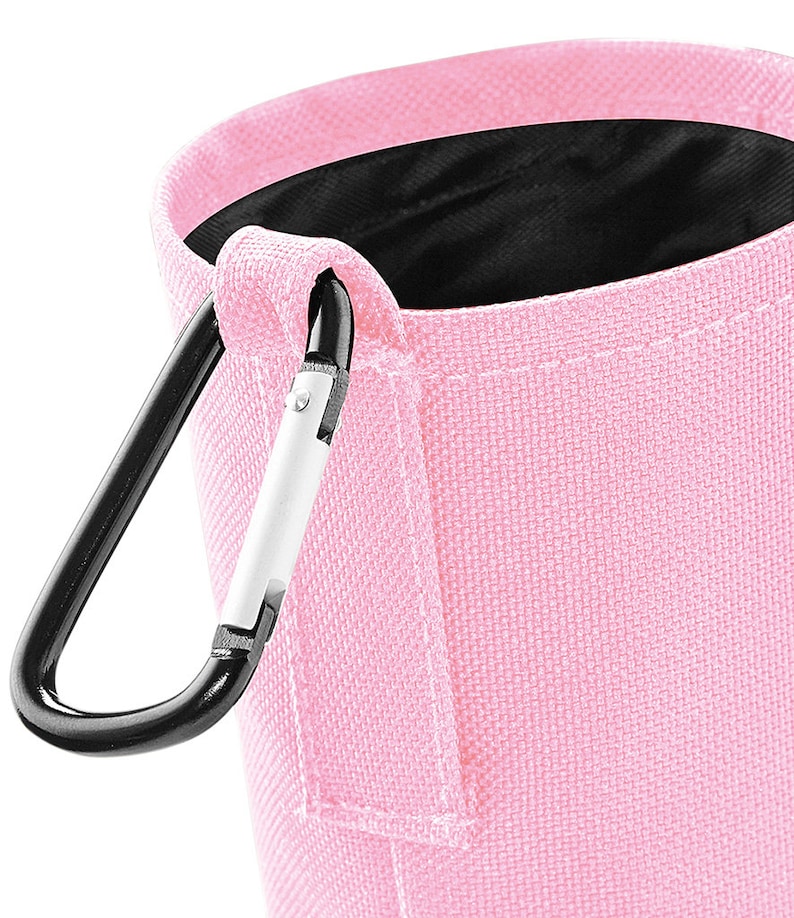 May include: A pink fabric pouch with a black carabiner clip. The pouch has a black lining and a small pocket on the side.