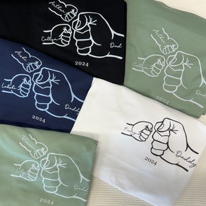 May include: Five white fist bump designs on different colored t-shirts. The designs include the names Arthur, Callum, Aishi, Lalohi, Finley, Vienna, Uly, and Daddy. The year 2024 is printed on each shirt.