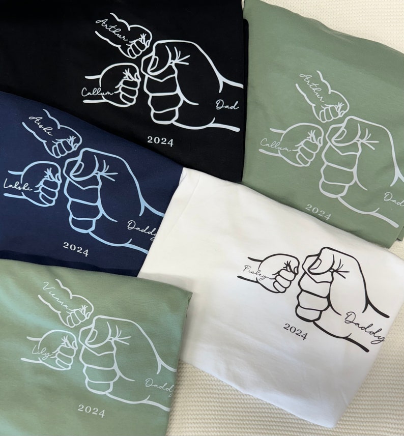 May include: Five white fist bump designs on different colored t-shirts. The designs include the names Arthur, Callum, Aishi, Lalohi, Finley, Vienna, Uly, and Daddy. The year 2024 is printed on each shirt.