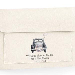 May include: White wedding planner folder with a vintage car illustration and the text "Wedding Planner Folder Mr & Mrs Taylor 22.12.2024" printed on the front.