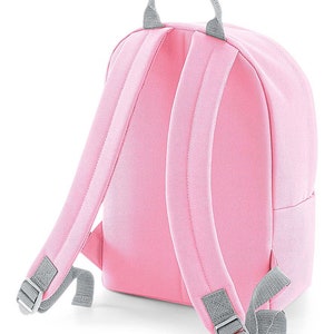 May include: A pink canvas backpack with gray adjustable straps and a gray top handle.