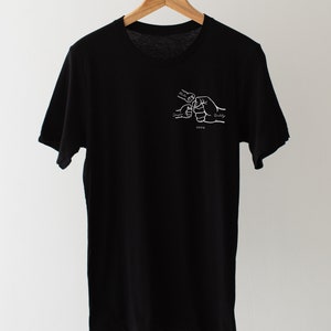 May include: Black t-shirt with a white graphic of four hands clasped together, labeled "Mommy", "Daddy", "Sister", and "Buddy". The year "2023" is printed below the hands.