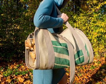 May include: A person carrying a large, beige and green canvas bag with a strap. The bag is filled with stacked pieces of firewood.