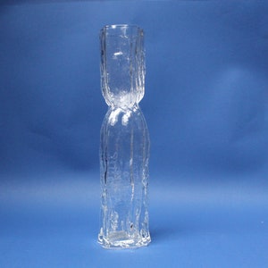 May include: A clear glass vase with a textured surface. The vase has a wide mouth and a narrow base.