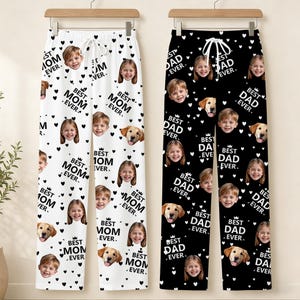 May include: Two pairs of personalized pajama pants, one white and one black. The white pants feature the text "Best Mom Ever" and the black pants say "Best Dad Ever". Both have photos of children, dogs, and heart shapes.
